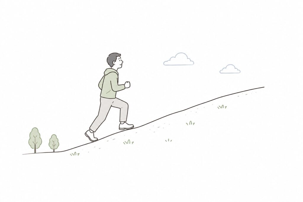 一歩ずつ坂道を登る人物